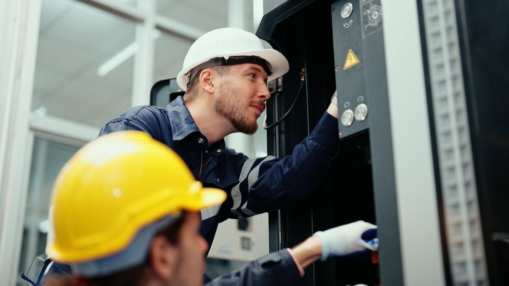 Two,Caucasian,Production,Engineers,In,Safety,Wear,Are,Assisting,In