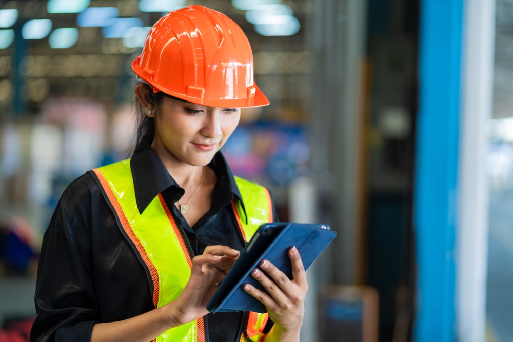 A,Woman,Wearing,A,Safety,Vest,And,An,Orange,Helmet