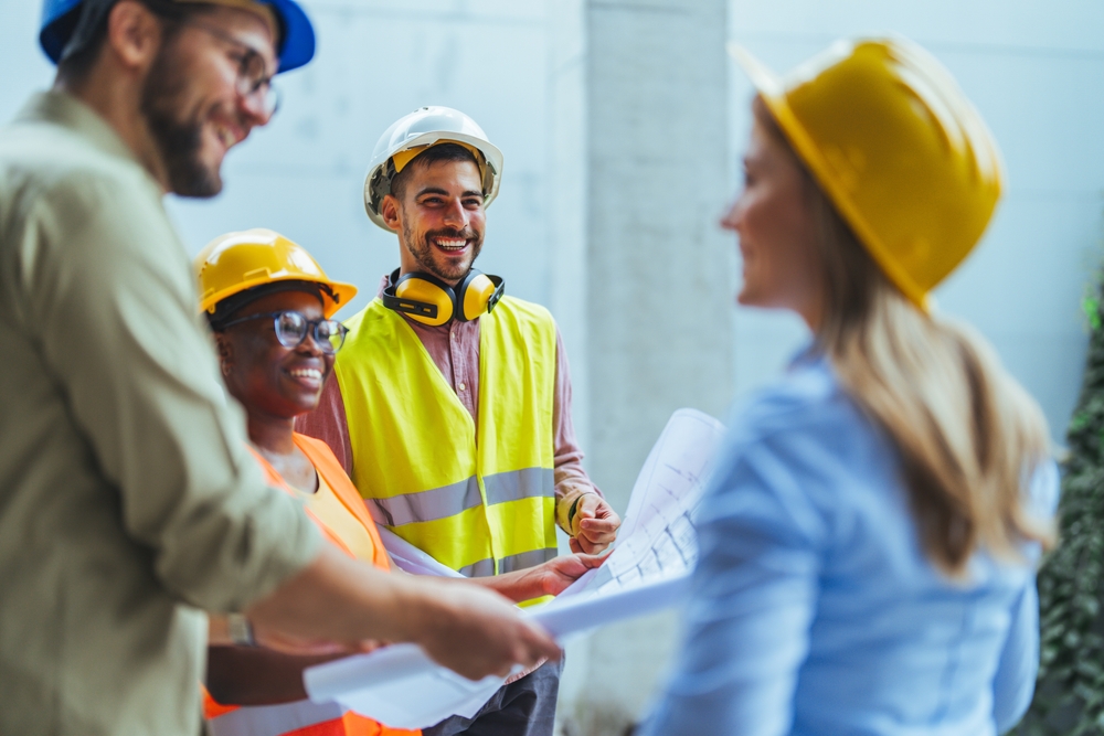 Engineers,Team,With,Draft,Plan,Of,Building,And,Tablet,Talking